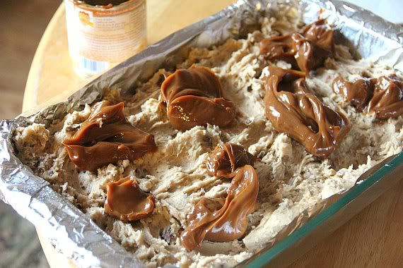 Globs of dulce de leche over batter in a baking pan