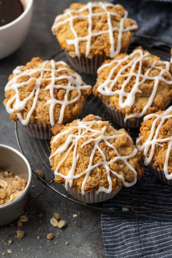 Overhead view of cinnamon muffins on a wire rack drizzled with glaze.