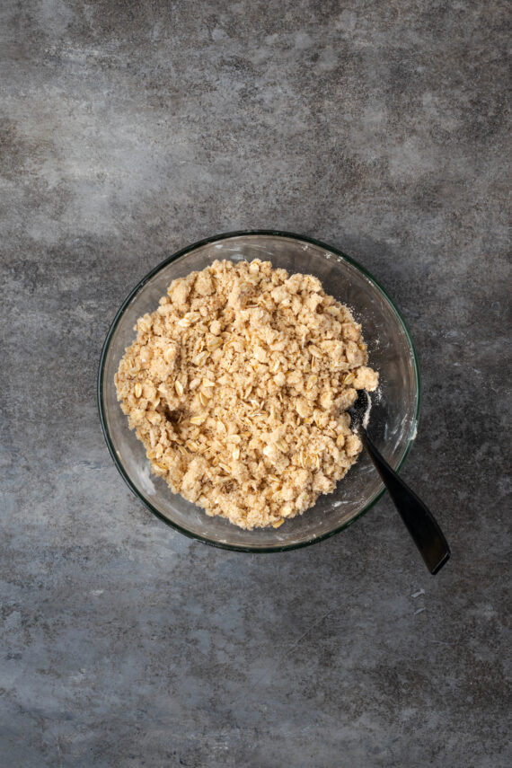 Oat streusel topping in a glass bowl with a fork.