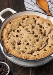 A skillet chocolate chip cookie in a large cast iron skillet.