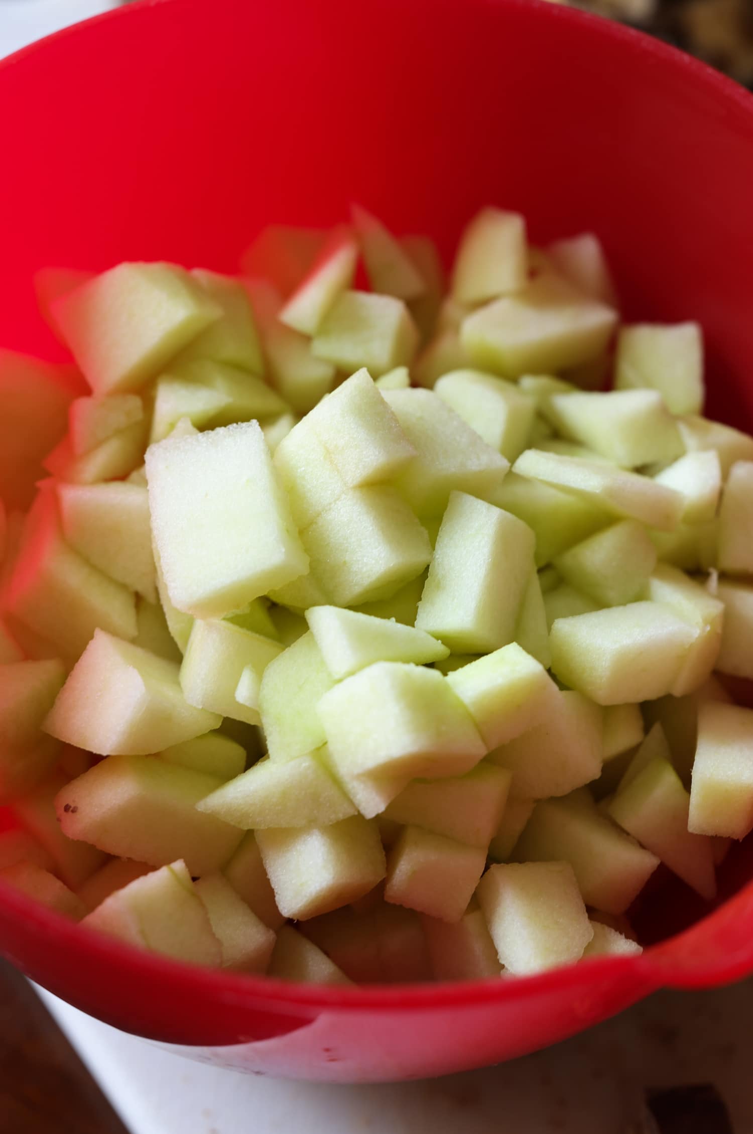 Granny Smith apples chopped in a red bowl