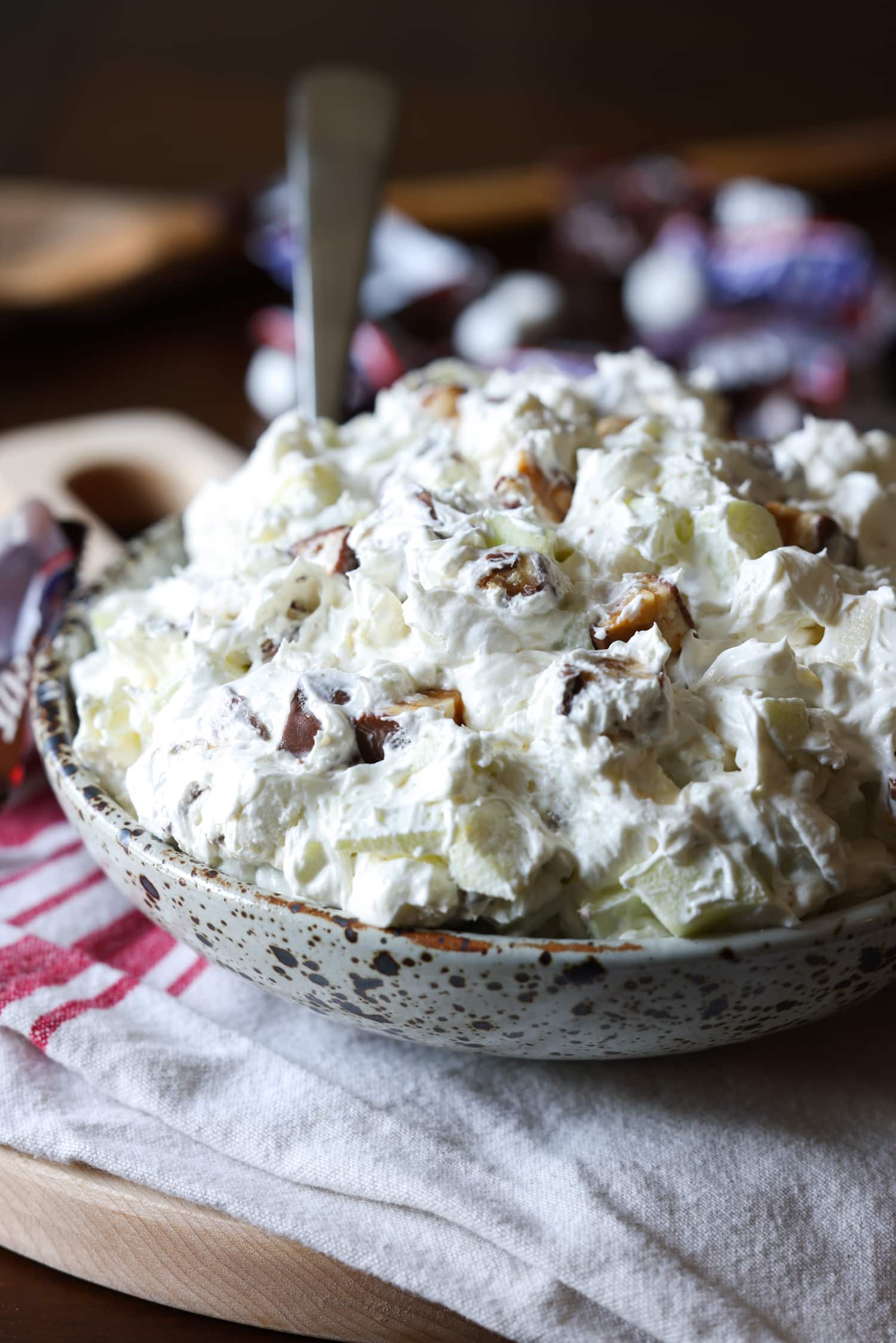 A bowl of caramel apple salad in a bowl with a spoon