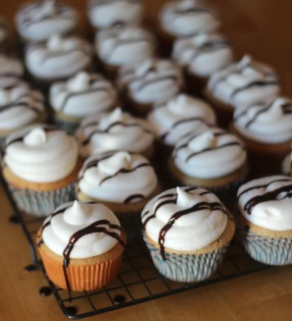 Root beer float cupcakes with vanilla frosting and chocolate drizzle on a cooling rack