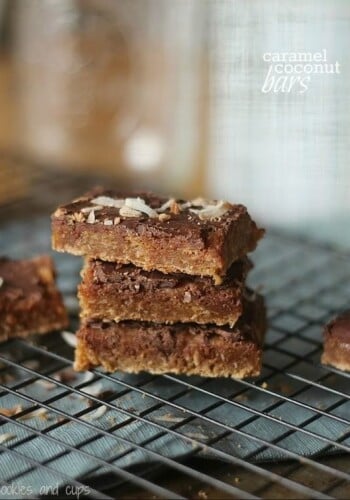 Three Caramel Coconut Bars stacked on a cooling rack