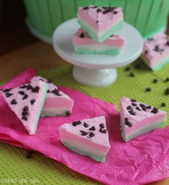 Triangles of pink and green layered watermelon fudge topped with mini chocolate chips