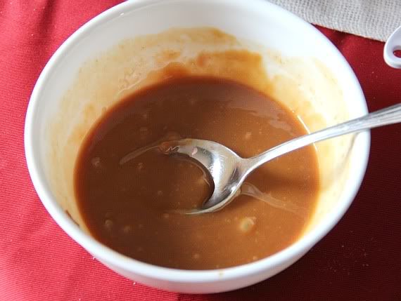 A bowl of caramel sauce with a spoon