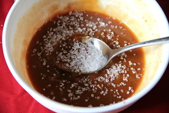 A bowl of caramel sauce topped with coarse sea salt