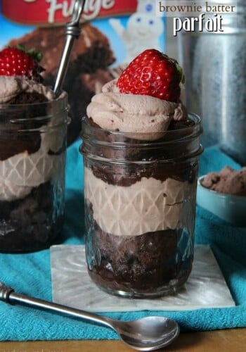 A brownie batter parfait in a jar with a strawberry on top