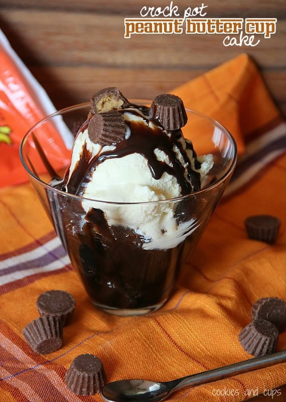 A serving of peanut butter cup cake with ice cream in a clear cup