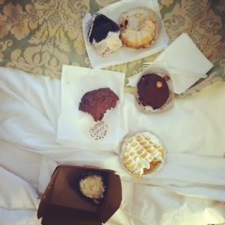 Top view of a variety of bakery treats on a hotel bed