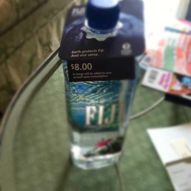 A bottle of Fiji water with an $8.00 price tag