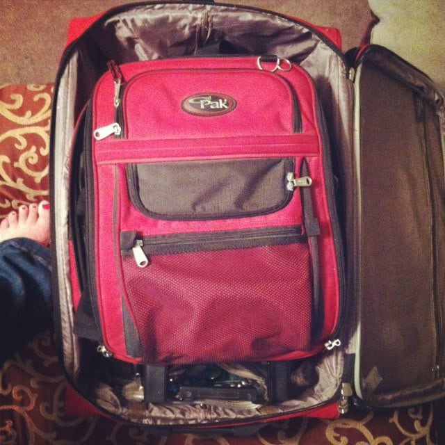 Top view of a red suitcase nested inside another suitcase