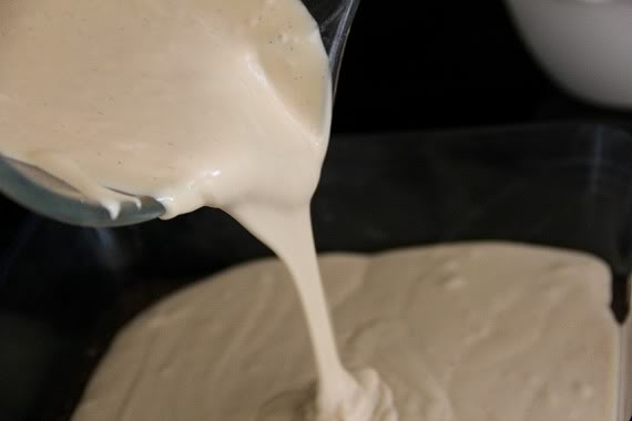 Cheesecake batter being poured into a baking pan