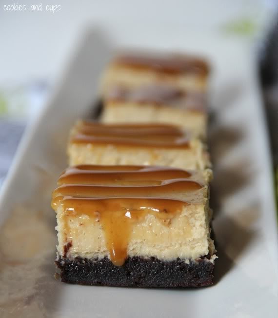Brownie bottom cheesecake bars with caramel drizzle on a rectangular platter