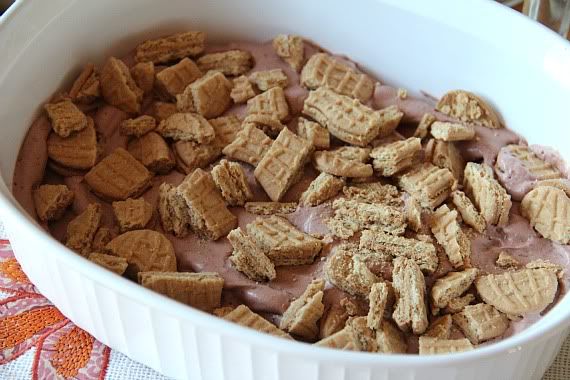 Crushed nutter butter cookies over chocolate pudding mixture in a casserole dish