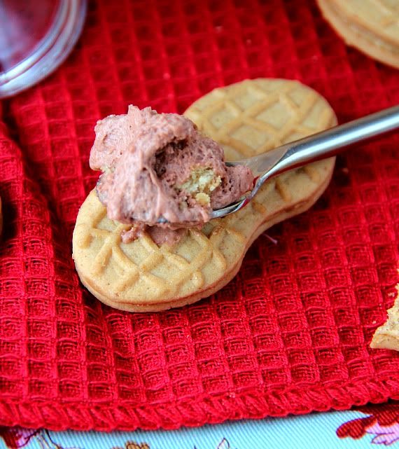 Nutter butter cookie being spread with frosting