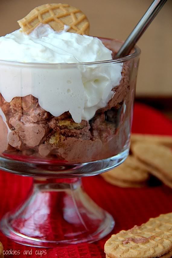 Chocolate nutter butter icebox cake topped with whipped cream in a dessert dish