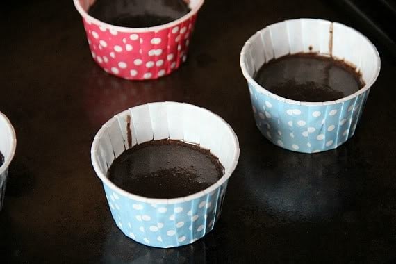 A few muffin cups filled with chocolate cupcake batter