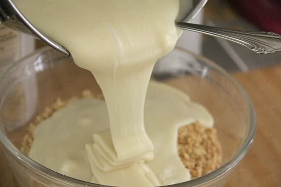 Melted white chocolate and sweetened condensed milk being poured into a mixing bowl