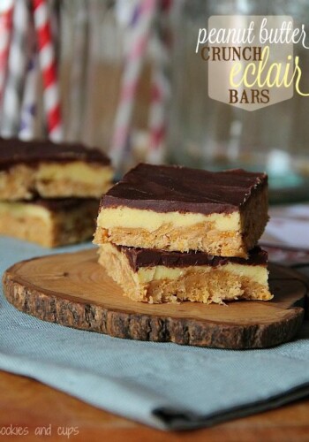 Two peanut butter eclair bars stacked on a wooden slice