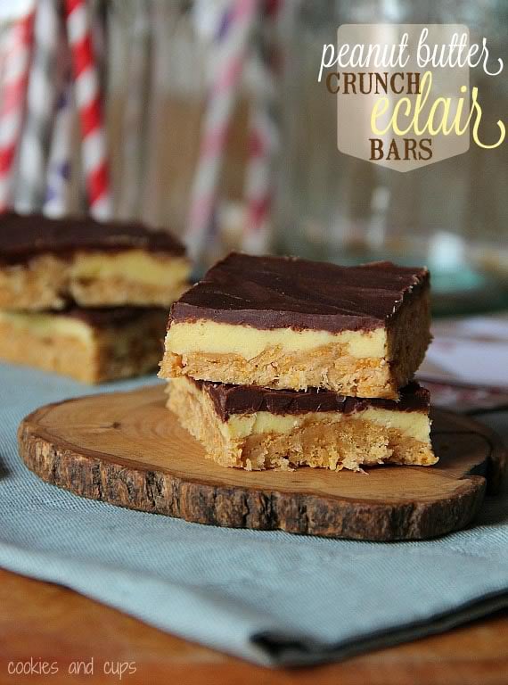 Two peanut butter eclair bars stacked on a wooden slice