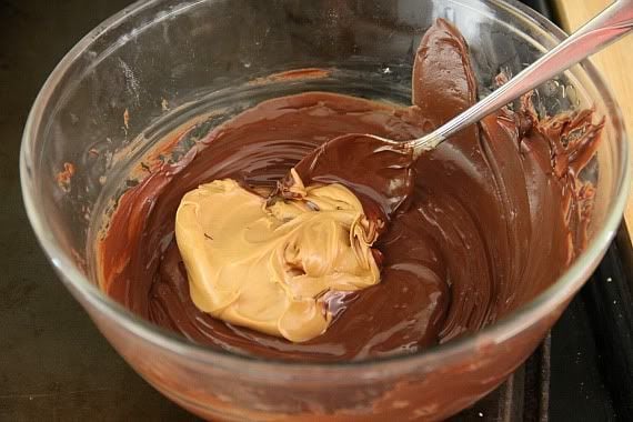 Melted chocolate with a glob of peanut butter in a mixing bowl