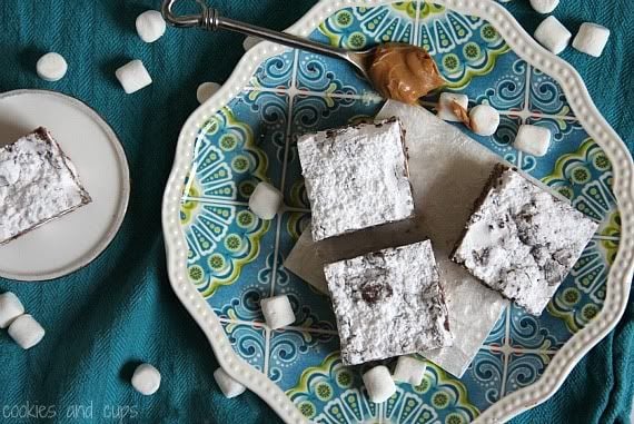 Top view of Puppy Chow Krispie Treat squares topped with powdered sugar on a plate 