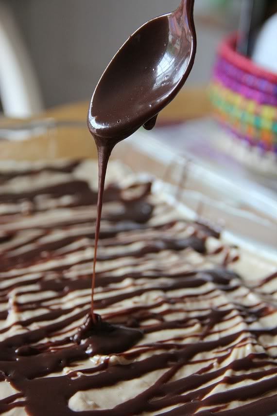 Chocolate being drizzled over peanut butter pie in a 9x13 pan