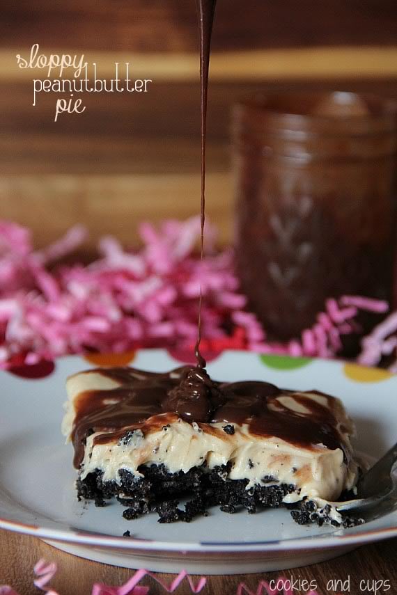 Side view of a serving of Sloppy Peanut Butter Pie on a plate with chocolate being drizzled on top