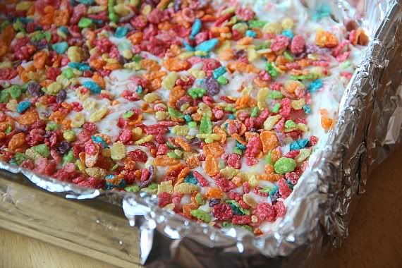 Fruity Pebbles fudge in a pan with extra Fruity Pebbles on top