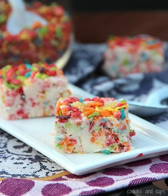 Two squares of Fruity Pebble Fudge on a white plate