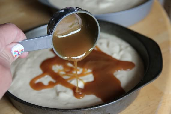 Caramel sauce being poured over yellow cake batter in a pan