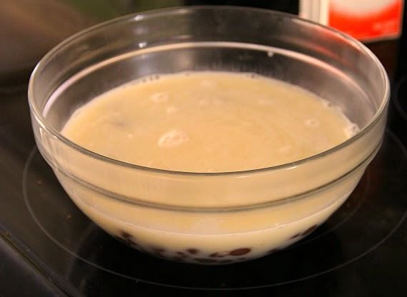A bowl of heavy cream with chocolate chips in the bottom