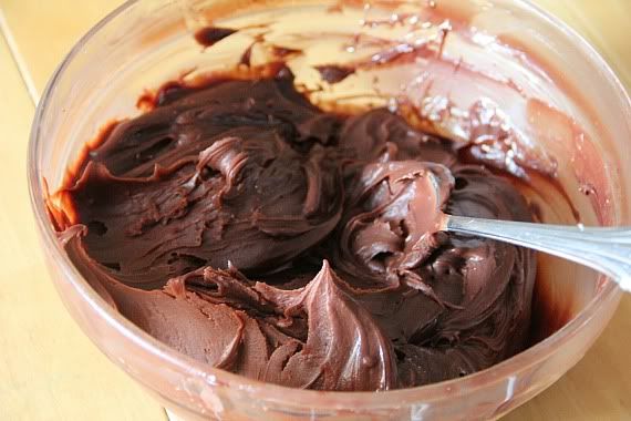 Chocolate frosting in a bowl with a spoon