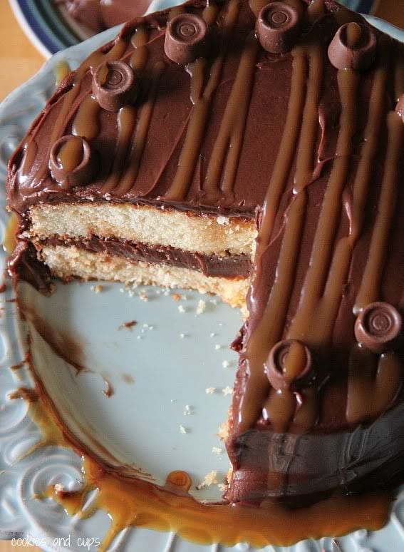 Top view of a two-layer round yellow cake with chocolate frosting with caramel and rolo candies