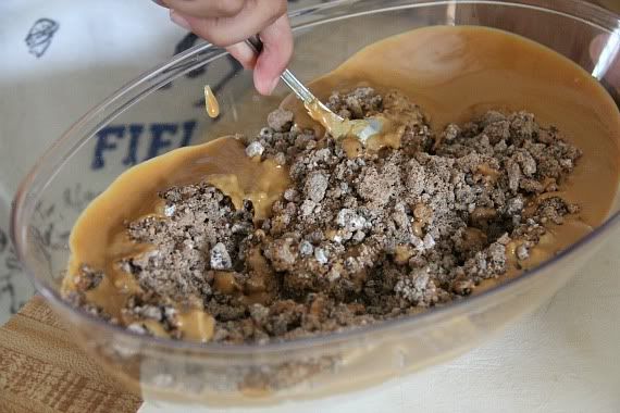 Melted peanut butter and crushed cookies in a mixing bowl