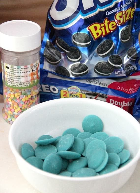 Teal melting wafers in a bowl next to a bag of mini oreos and sprinkles