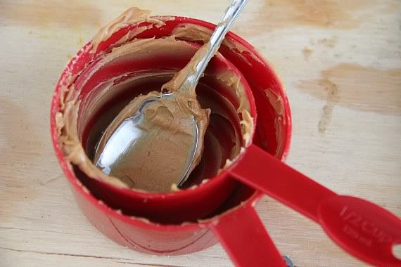 Two empty measuring cups with peanut butter residue