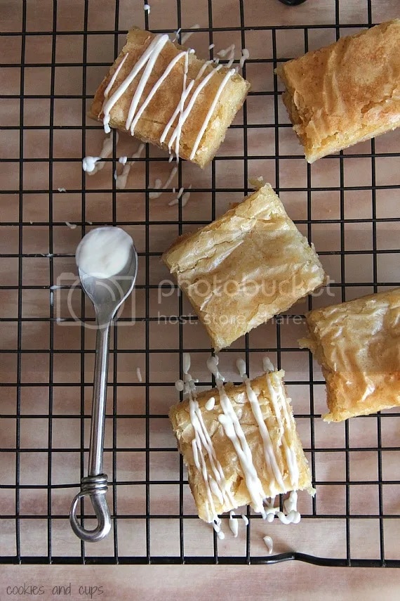 Overhead view of white chocolate brownies on a cooling rack with drizzled glaze