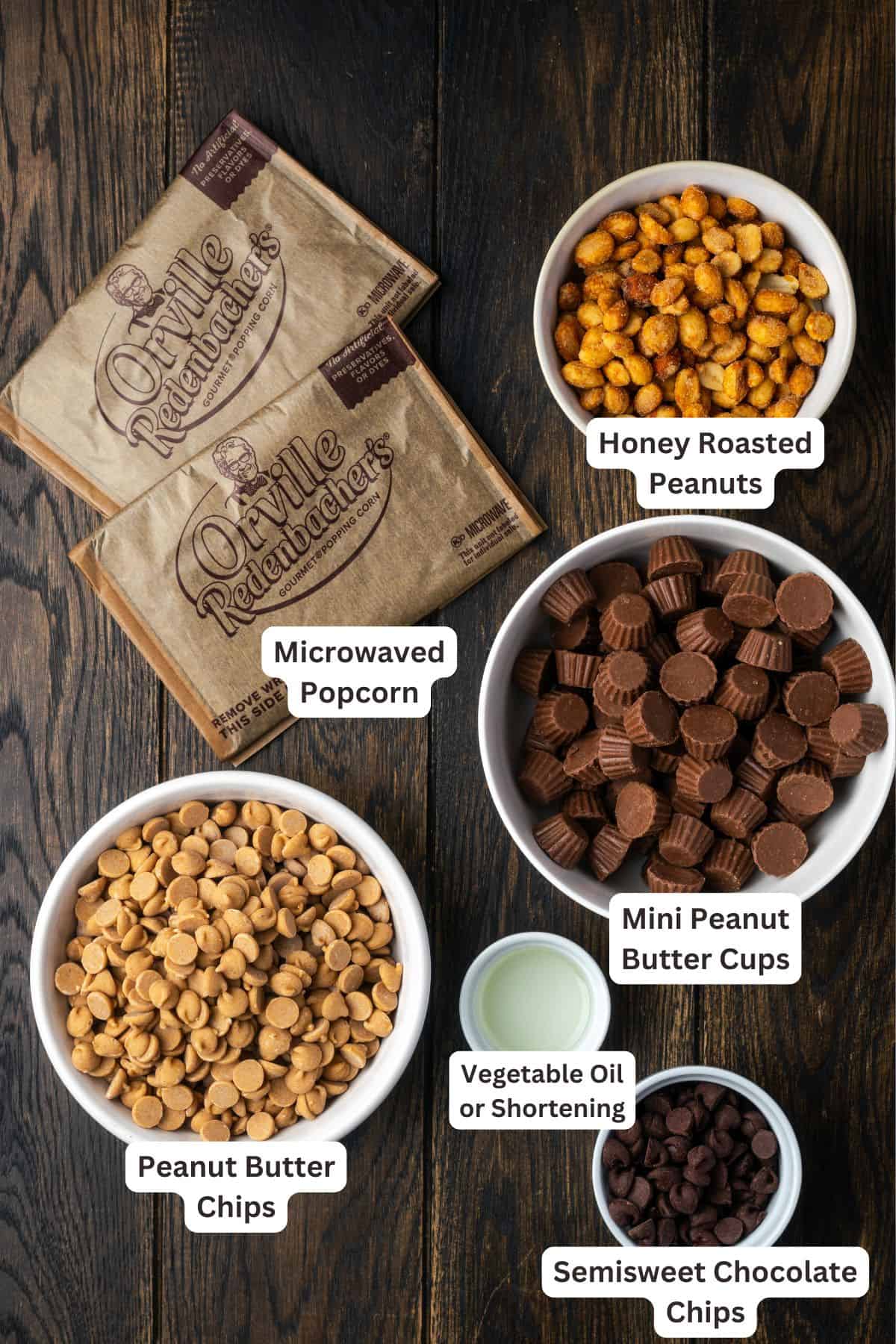 Peanut butter popcorn turns microwave popcorn into the ultimate sweet snack, tossed with peanut butter cups and drizzled with chocolate! Peanut butter popcorn ingredients with text labels overlaying each ingredient.