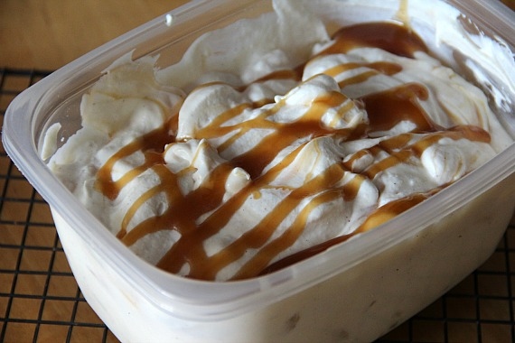 Plastic container of homemade ice cream with caramel drizzled on top