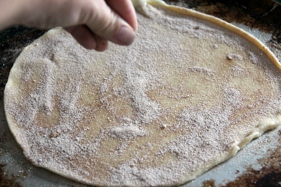 Pie crust dough being sprinkled with cinnamon sugar
