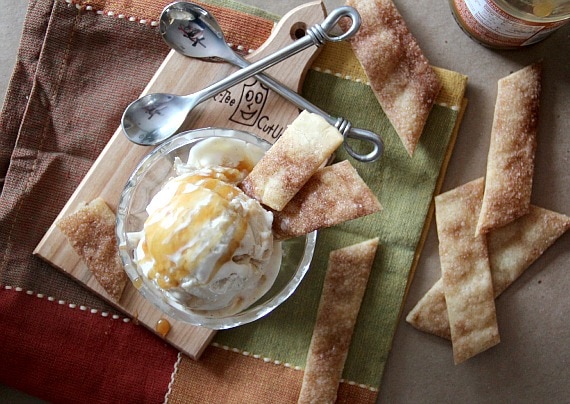 Top view of a dish of caramel drizzled ice cream with cinnamon pie crust pieces