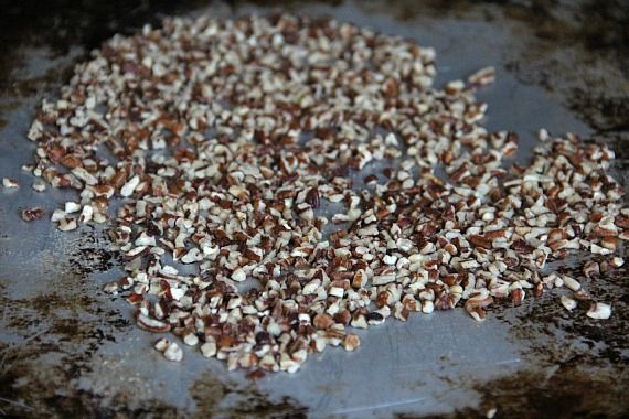 Chopped toasted pecans on a baking sheet