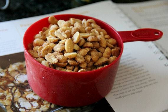 A measuring cup of honey roasted peanuts