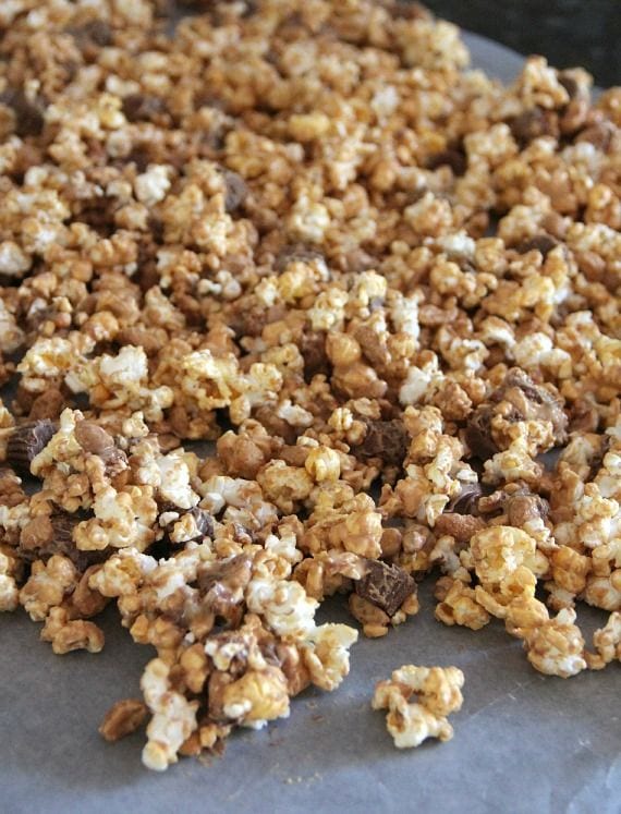 Peanut butter coated popcorn spread on wax paper