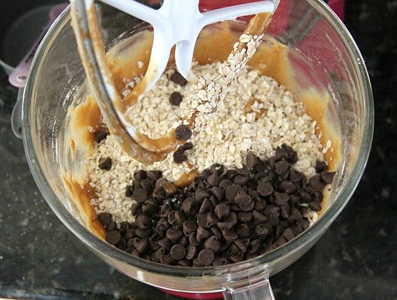 Mashed banana mixture, oats, and chocolate chips in a mixing bowl