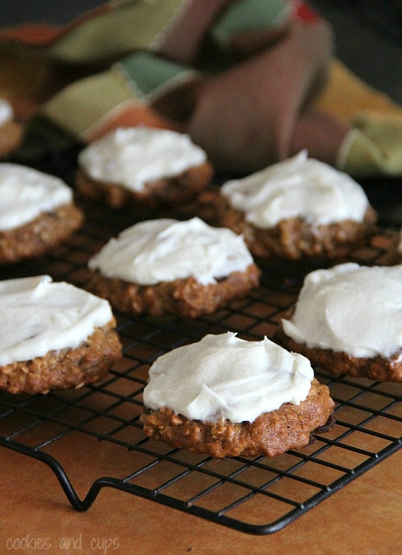 Banana bread cookies with maple cream cheese frosting on a cooling rack