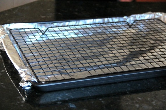 A baking sheet line with foil with a cooling rack on it