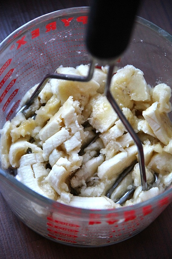 Bananas being mashed in a measuring cup